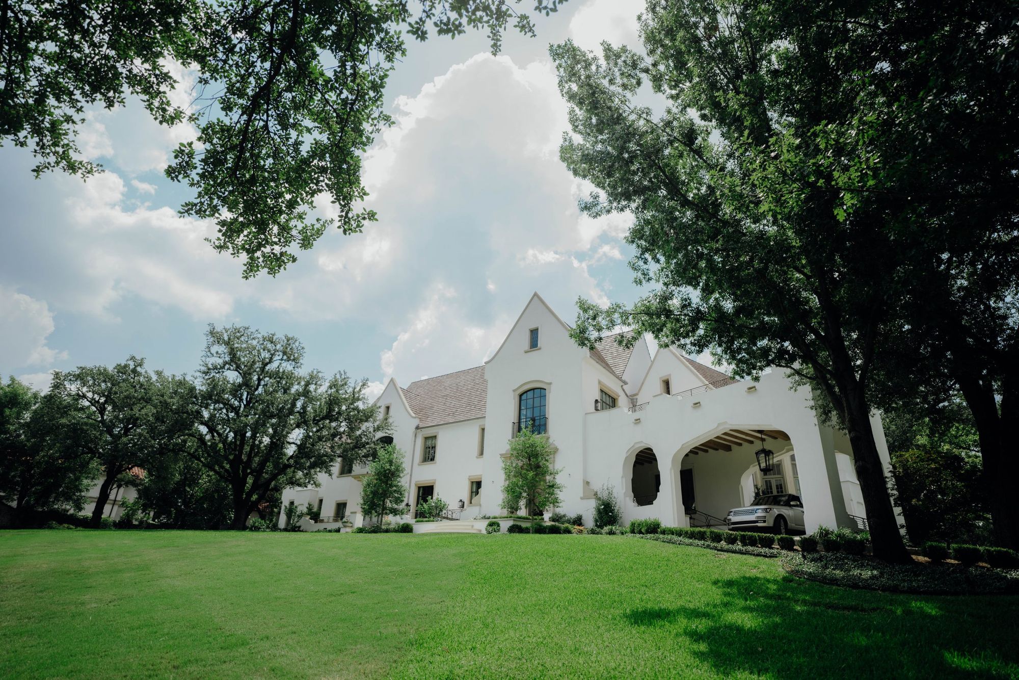 Front lawn and gabled facade under oak trees