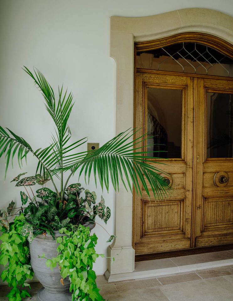 Arched wood entry doors in a stone surround