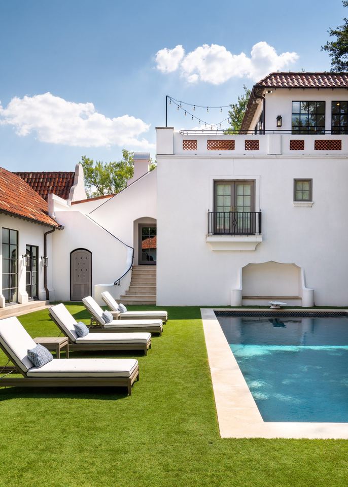 Pool court enclosed by white stucco walls and tile roofs