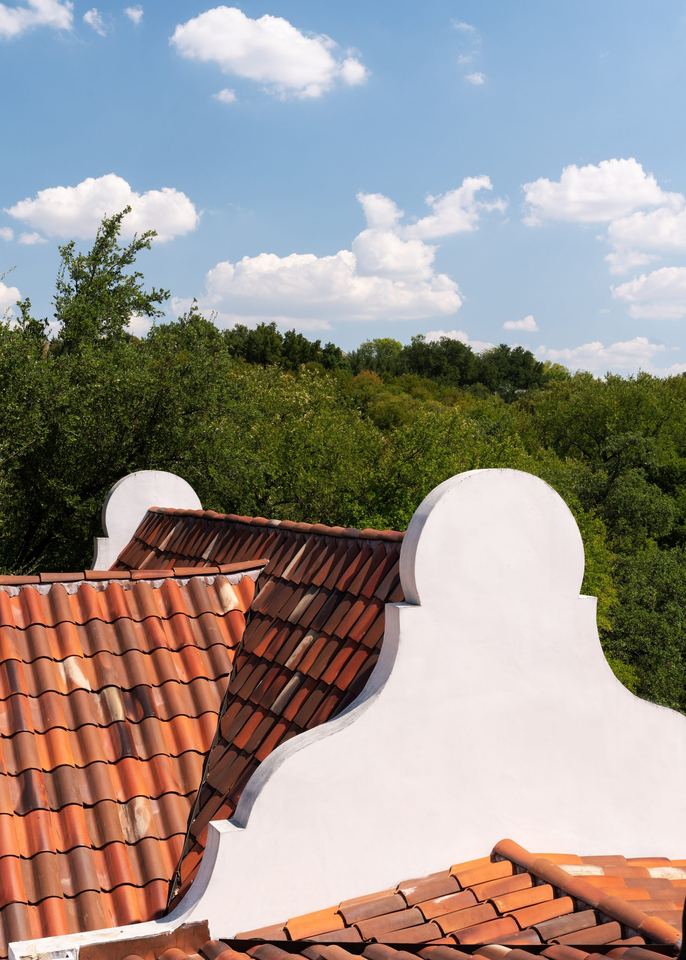 Curved parapets and clay tile against the sky