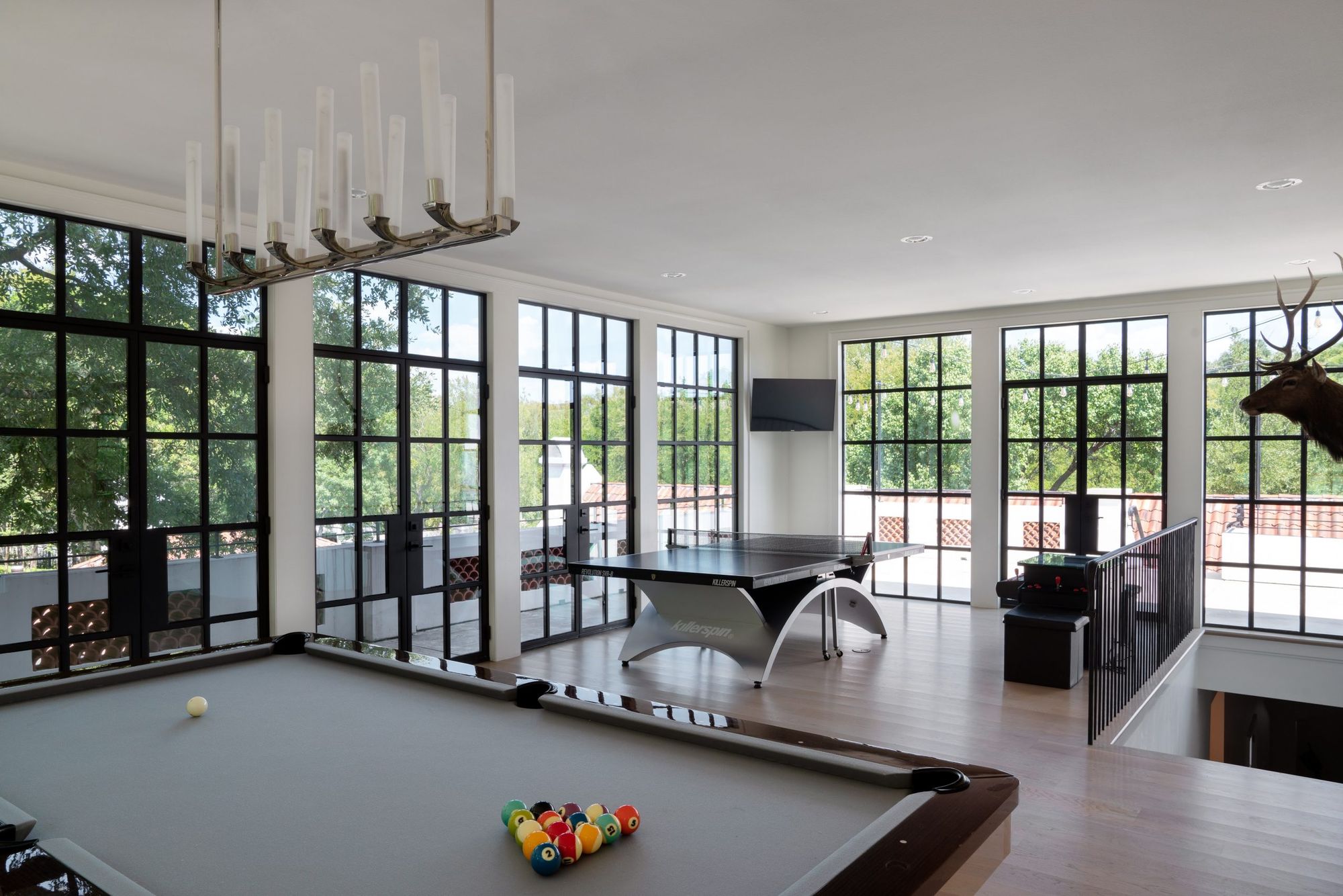 Game room surrounded by steel windows