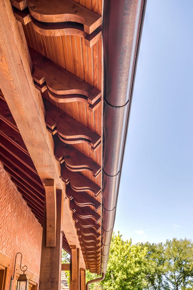 Carved cedar rafter tails under the eave