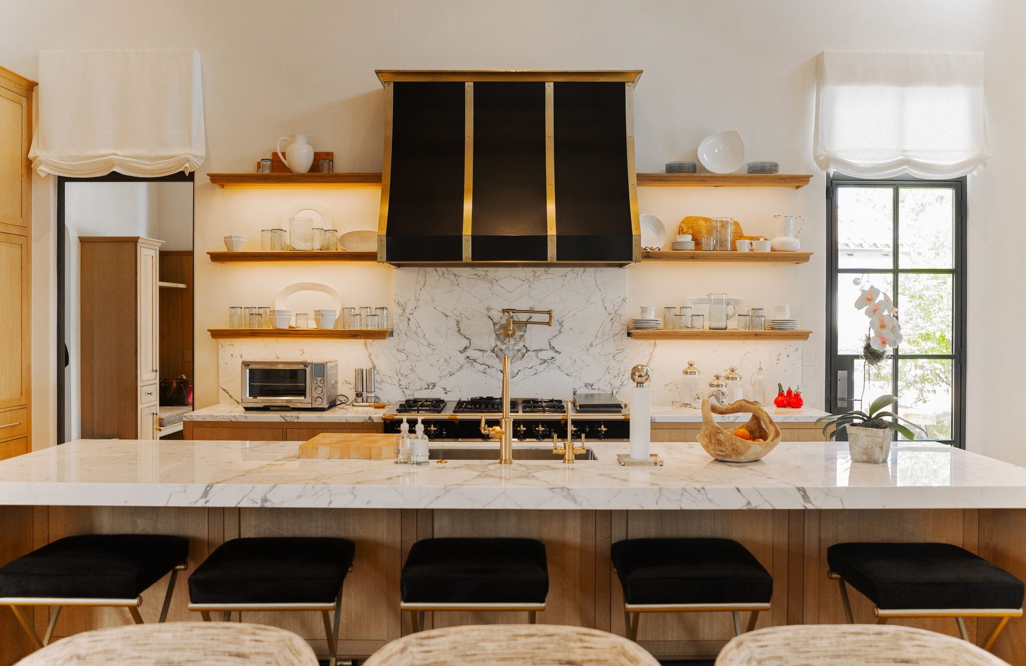 Kitchen with open shelving and a black range hood